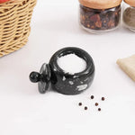 Black marble salt cellar filled with white Himalayan salt, lid resting beside it, 3 inches wide and tall