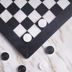 Black and white marble checkers set 15 inch — board corner detail with white and black marble disc pieces on marble surface by RADICALn