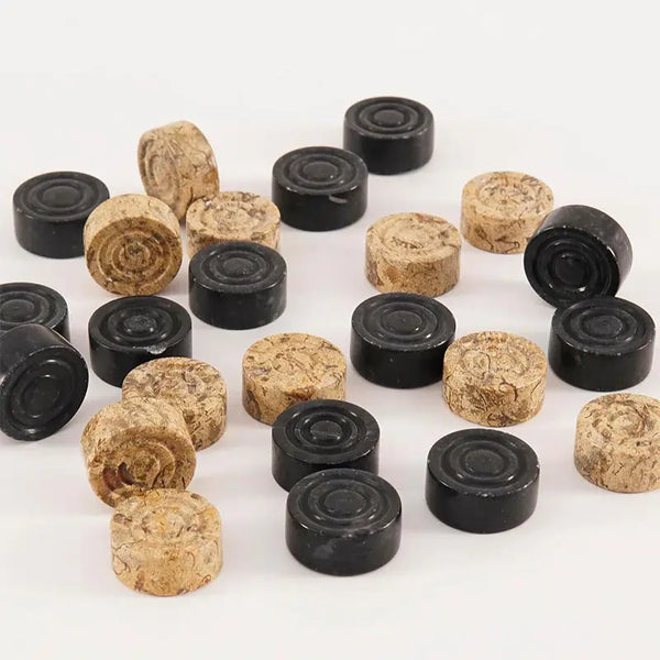 Black and fossil coral marble checkers discs overhead view — 32 natural stone pieces scattered by RADICALn