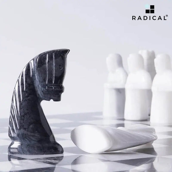 Black marble antique knight chess figure close-up — hand-carved medieval horse form with white marble pawns on board by RADICALn