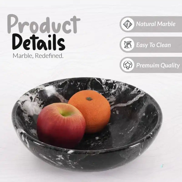 Black marble fruit bowl holding an apple and an orange, showing the polished natural stone finish