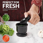 Black marble mortar and pestle used to grind fresh herbs for pesto, guacamole and salsa