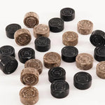 Black and oceanic marble checkers discs scattered on white surface — concentric ring and felt bottom detail by RADICALn