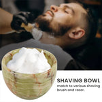 Green onyx marble shaving bowl full of lather with a barbershop shave in the background