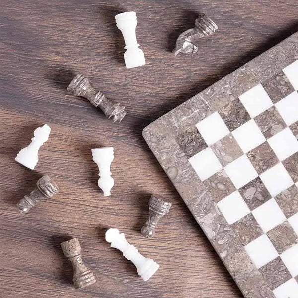 Grey oceanic and white marble chess set 12 inch — pieces scattered on dark wood surface showing oceanic grey and white marble stone detail by RADICALn