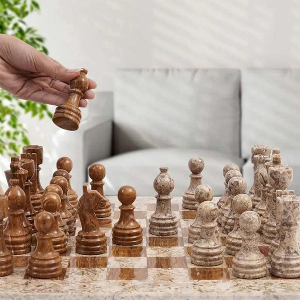Hand lifting dark brown marble rook piece — fossil coral and dark brown marble chess set 15 inch in home living room by RADICALn