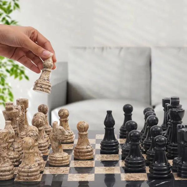 Hand lifting fossil coral marble rook piece — black and fossil coral marble chess set 15 inch in home living room setting by RADICALn