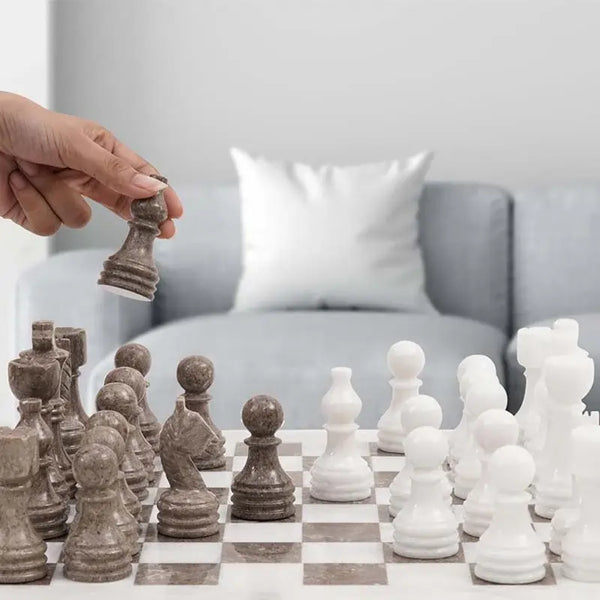 Hand lifting grey oceanic marble rook piece — white and oceanic grey marble chess set 15 inch in contemporary home living room by RADICALn