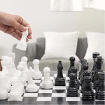 Hand lifting white marble pawn — black and white marble chess set 15 inch in living room by RADICALn