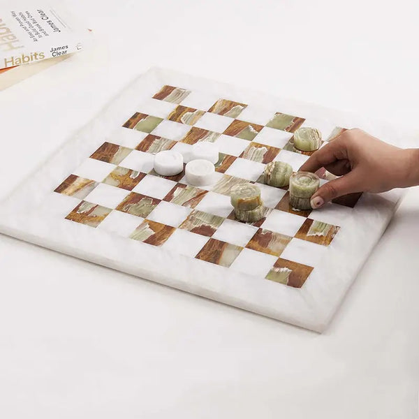 Hand placing green marble checkers disc mid-game — white and green marble checkers set 15 inch with books by RADICALn