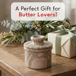 Natura brown marble butter keeper presented as a gift in front of a wrapped box with a light green ribbon