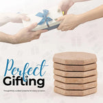 Stack of six travertine octagon coasters shown as a gift alongside a wrapped present