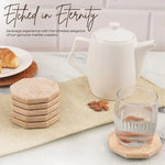 Travertine octagon coasters on a linen runner beside a teapot and a glass of water