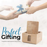 Square travertine coaster set with holder shown as a gift alongside a wrapped present
