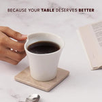 Square verona coaster on a desk as a hand lifts a white coffee mug