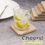 Square travertine coasters under a glass of iced lemon water with the set stacked behind