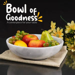 White marble fruit bowl filled with apples, grapes and a pear as a table centerpiece