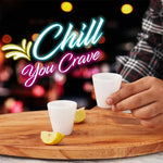 Hand holding a white marble shot glass at a bar with lemon on a wooden board