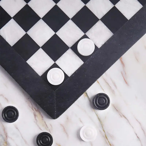Black and white marble checkers set 15 inch — board corner detail with white and black marble disc pieces on marble surface by RADICALn