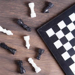 Black and white marble chess set 12 inch — pieces scattered on dark wood surface showing black and white marble stone detail by RADICALn