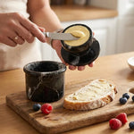 Radicaln black marble butter keeper holding soft butter while a slice of toast is buttered