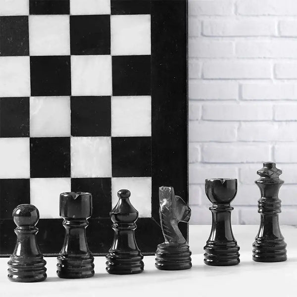 Black marble chess pieces lineup — pawn bishop knight rook king queen with black and white board edge by RADICALn