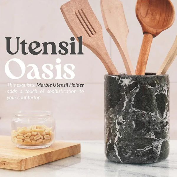 Black marble crock for utensils holding wooden spatulas on a kitchen countertop