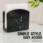 Black marble napkin holder filled with white napkins on a styled countertop