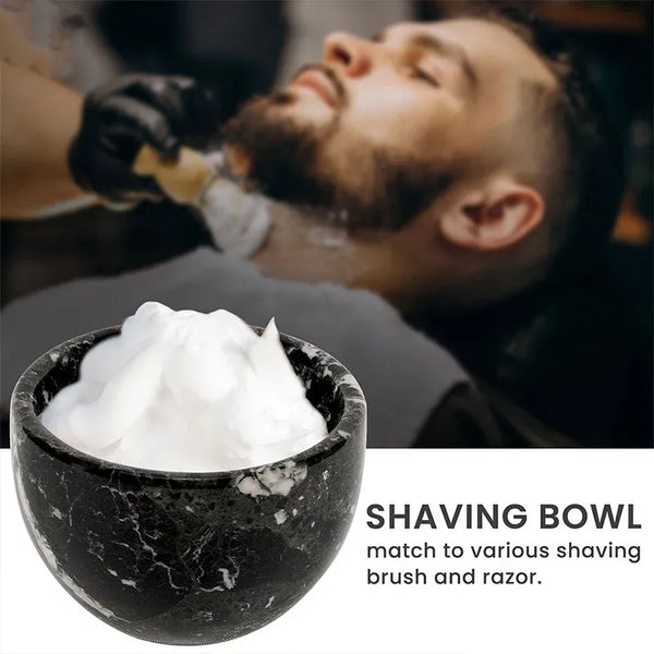 Black marble shaving bowl full of lather with a barbershop shave in the background