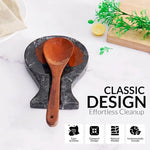 Black marble spoon rest holding a wooden ladle on a countertop