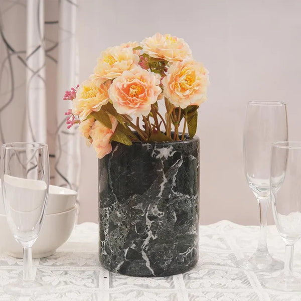 Black marble utensil holder used as a flower vase on a set dining table