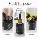 Black marble wine cooler holding utensils, a wine bottle and flowers