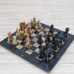 Black and multi green onyx marble chess set 15 inch — all 32 pieces in starting position on wood surface by RADICALn