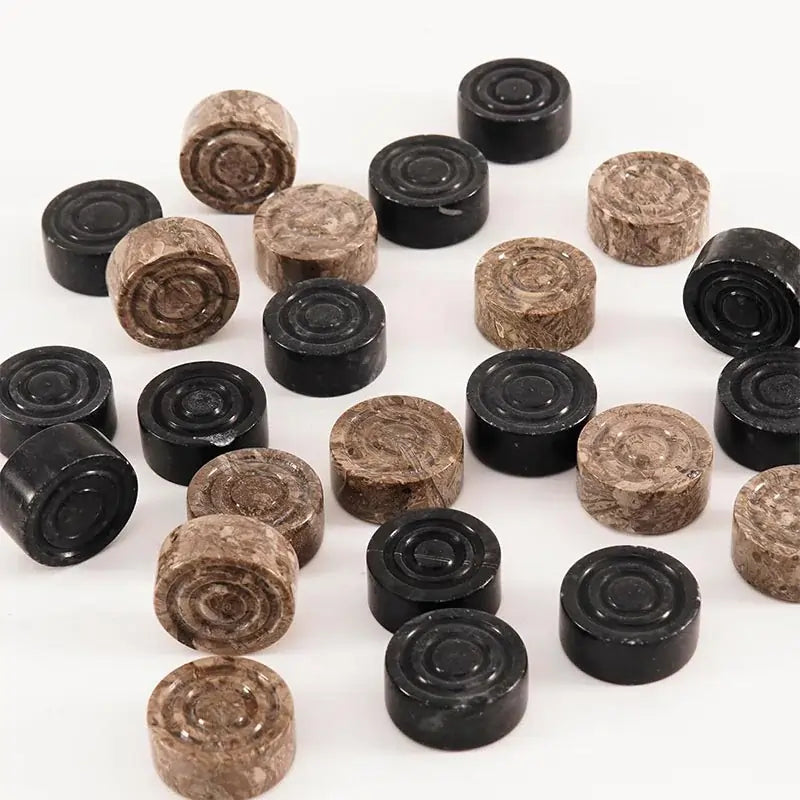 Black and oceanic marble checkers discs scattered on white surface — concentric ring and felt bottom detail by RADICALn
