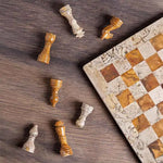 Coral and red marble chess set 12 inch — pieces scattered on dark wood surface showing fossil coral and red marble stone detail by RADICALn