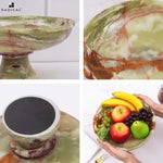 Green onyx marble pedestal fruit bowl shown from the side, close up, from underneath with its felt base, and held full of fruit
