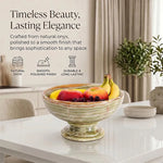 Green onyx marble pedestal fruit bowl holding fruit on a dining table, noting its natural stone and polished finish