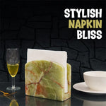 Green onyx marble table napkin holder with folded napkins beside a wine glass and gold fork