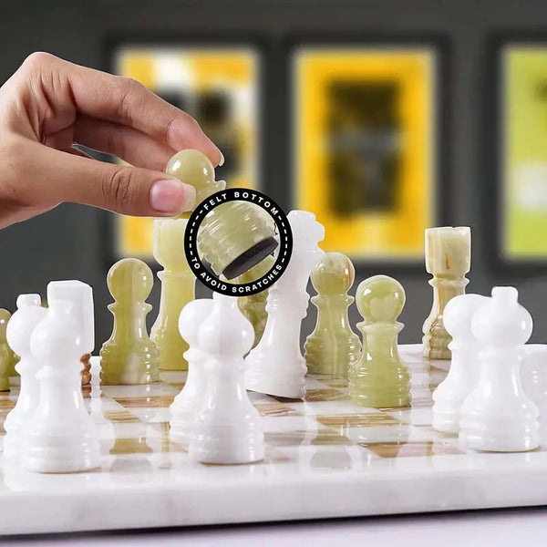 Hand lifting green onyx chess pawn with felt bottom detail — white and green onyx pieces in starting position by RADICALn