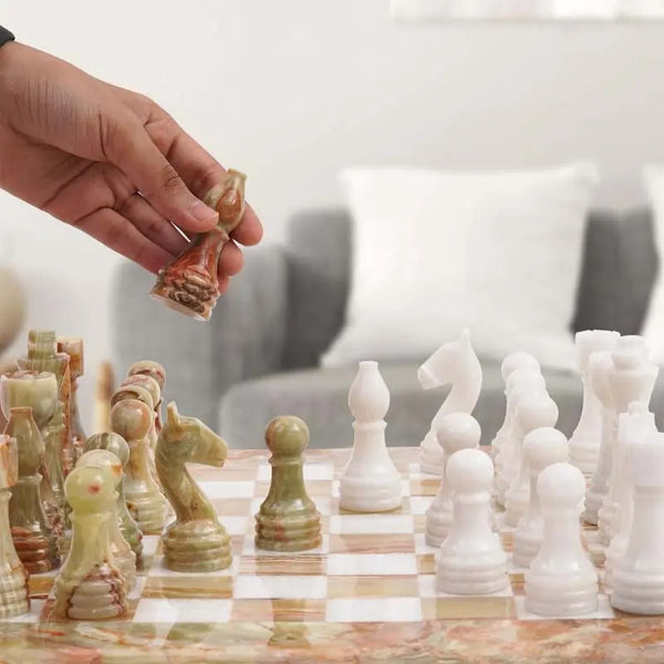 Hand lifting green onyx knight piece — green onyx and white marble chess set 15 inch in living room by RADICALn