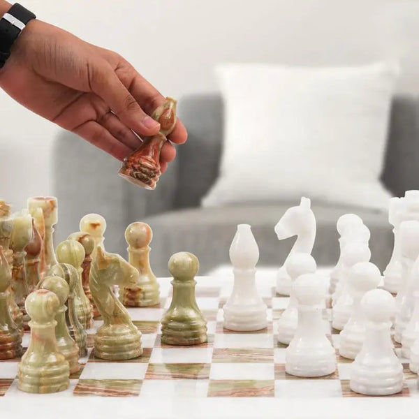 Hand lifting green onyx marble bishop piece — white and green onyx marble chess set 15 inch with storage box in home living room by RADICALn