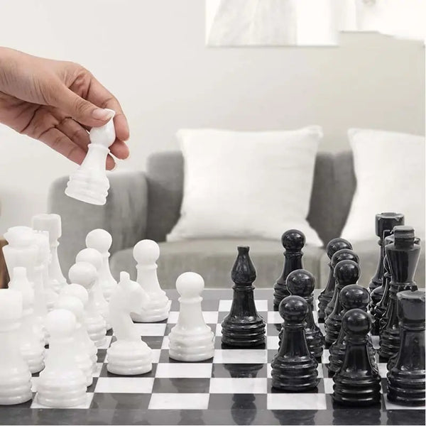 Hand lifting white marble pawn — black and white marble chess set 15 inch in living room by RADICALn