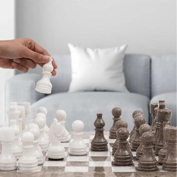 Hand lifting white marble pawn piece — oceanic grey and white marble chess set 15 inch in contemporary home living room by RADICALn