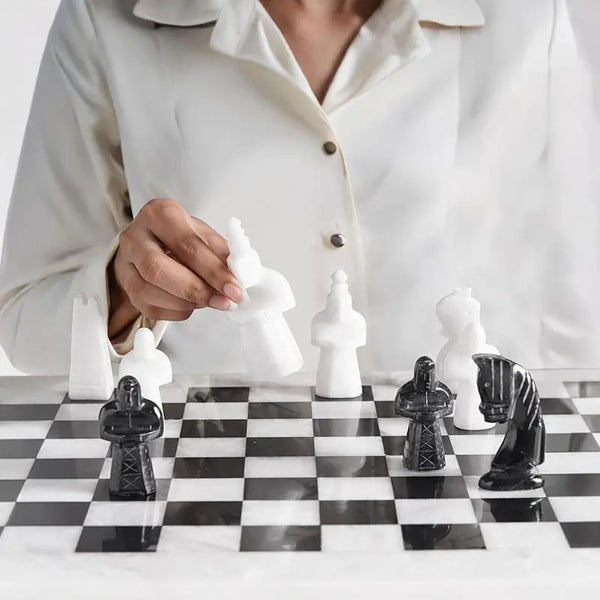 Hand moving white marble rook tower piece — white and black antique medieval figurative chess pieces close-up by RADICALn