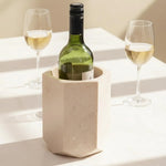 Verona hexagon marble wine chiller holding a white wine bottle beside two filled glasses