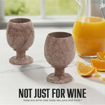 Pair of marinara marble wine glasses beside an orange juice pitcher for any cold drink
