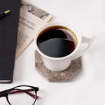 Oceanic octagon marble coaster under a white coffee cup beside a newspaper and glasses