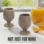Pair of oceanic marble wine glasses beside an orange juice pitcher for any cold drink