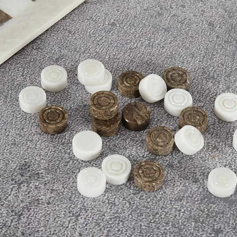 Oceanic and white marble checkers discs scattered on grey textured surface — concentric ring and felt bottom detail by RADICALn