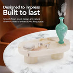 Raised white onyx marble tray on fluted legs holding earbuds and a vase on a side table